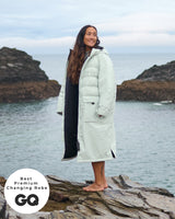 Lead_women - Woman wearing a Vivida Lifestyle All Weather Puffer Changing Robe, Matcha Green Drying Robe for swimming. Sticker: Best Premium Changing Robe - The Independent.