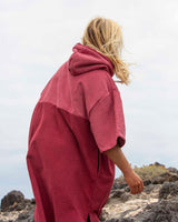 Lead_men2 - Man wearing a Vivida Original Adult Poncho Towel Changing Robe - Blossom Pink / Rhubarb Red. Sticker reads Women's Health's Best Towelling Changing Robe