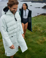 Man wearing a Vivida Lifestyle All Weather Puffer Changing Robe, Matcha Green Drying Robe for swimming. Sticker: Best Premium Changing Robe - The Independent.