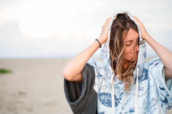 Woman drying hair in a Vivida Lifestyle Surf & Swim Poncho Towel Changing Robe