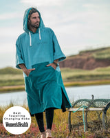 Man wears a Vivida Original Poncho Towel Changing Robe - Turquoise Teal / Pacific Teal