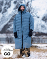 Lead_men - wearing a Vivida Lifestyle All Weather Puffer Changing Robe, Mineral Blue Drying Robe for swimming standing in snow. Sticker: Best Premium Changing Robe - The Independent and GQ Magazine