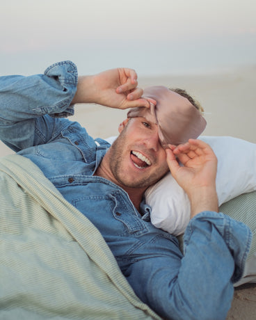 Man wearing a misty rose Vivida silk sleep mask
