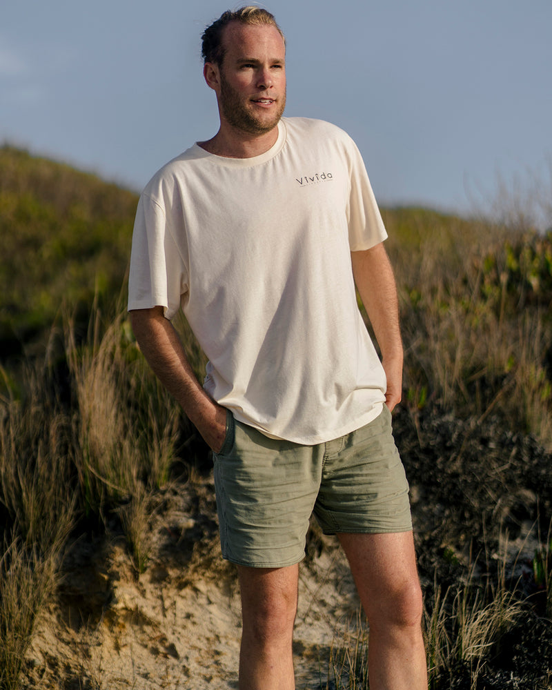 Man wearing a Vivida Lifestyle Into the Wild Classic Organic Cotton T-Shirt in Beach Ivory