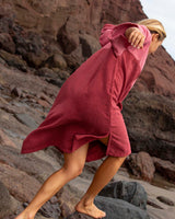 Woman running wearing the Original Poncho Towel Changing Robe - Blossom Pink / Rhubarb Red