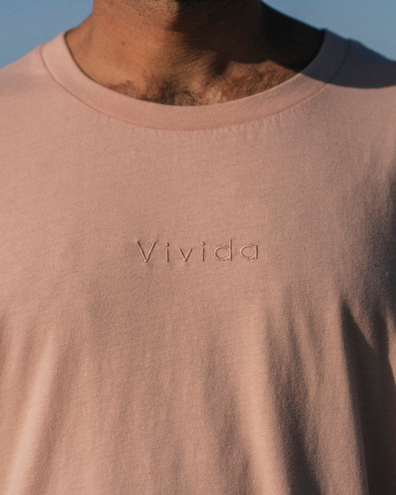 Man wearing a Vivida Lifestyle Classic Tee Embroidered T-Shirt misty rose