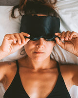 Woman wearing a Vivida Silk Blackout Eye Mask - Midnight Black