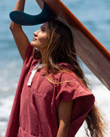 Woman with surfboard wearing Essential Poncho Towel Changing Dry Robe Rhubarb Red