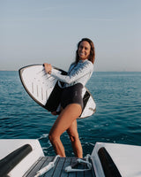 Woman wearing a Vivida Linda Reversible Shortie Neoprene Wetsuit - Graphite / Map of Dreams sailing