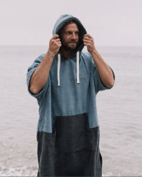 Surfer using a Vivida poncho towel at the coast