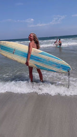 Woman surfing wearing the Vivida Hermosa Bikini Top and Nefeli Bikini Bottoms