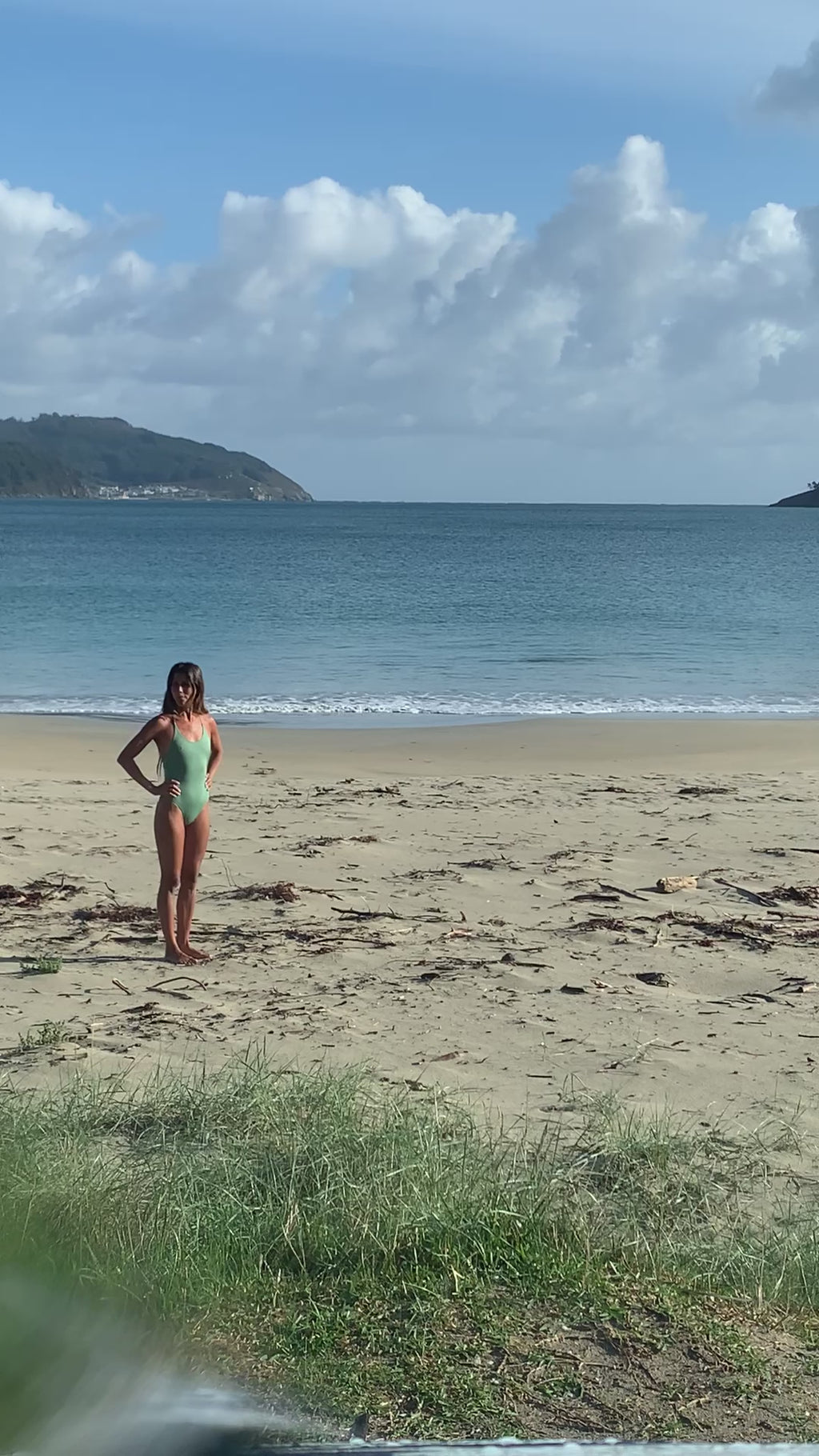 Woman walks on the beach wearing a Georgina Surf Swimsuit