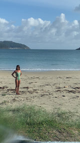 Woman walks on the beach wearing a Georgina Surf Swimsuit